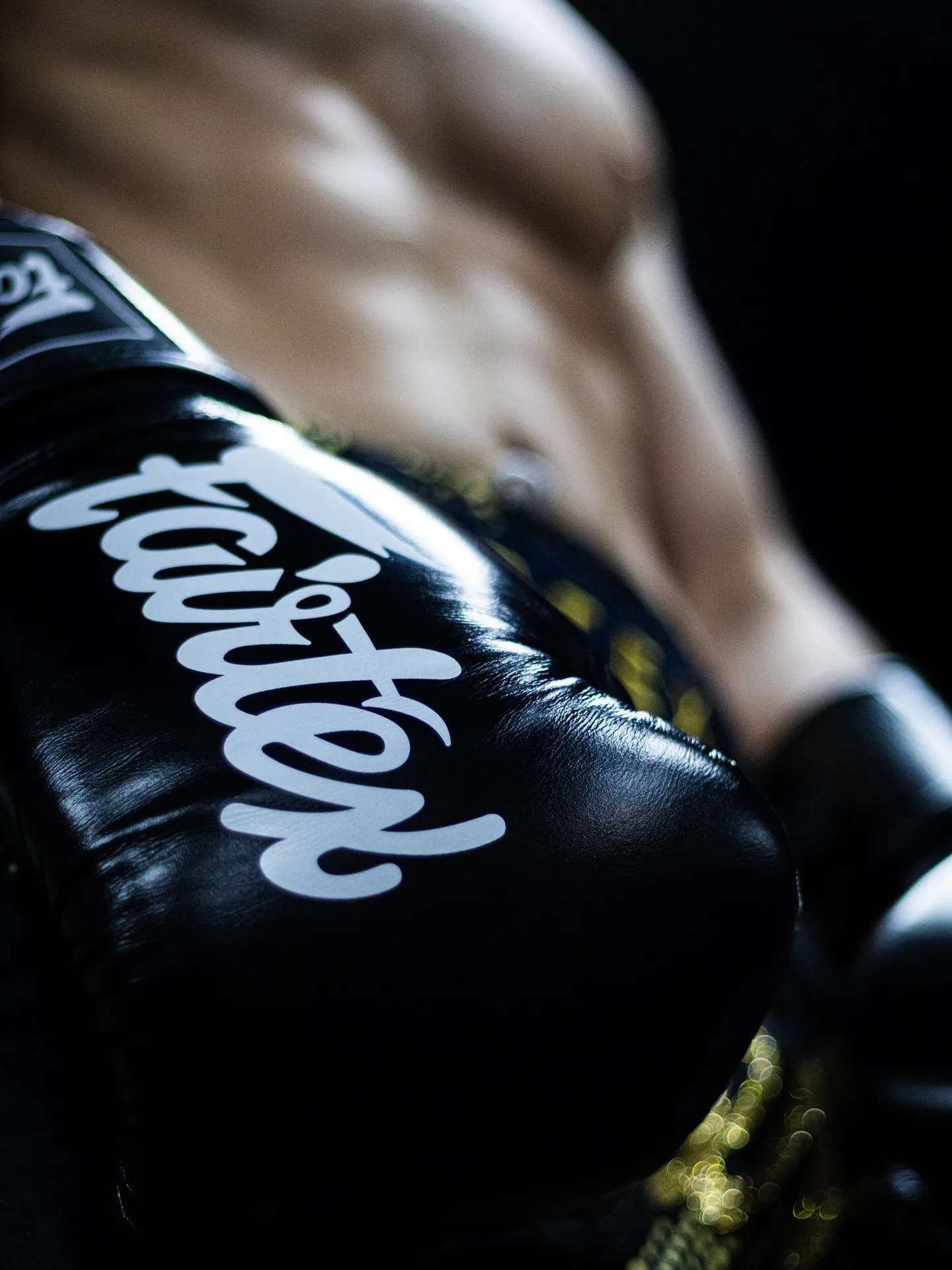 Nyrkkeilijä harjoittelee mustilla Fairtex-hanskoilla